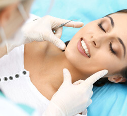 Dentist examining a woman’s smile