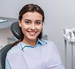 A smiling young woman sitting in a dentist’s chair