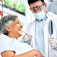 Dentist showing patient smiling in reflection